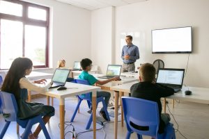 confident teacher explaining lesson pupils