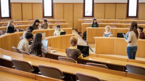 group students circular classroom with teacher explaining lesson