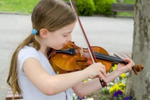 little beautiful girl busker play violin park spring day