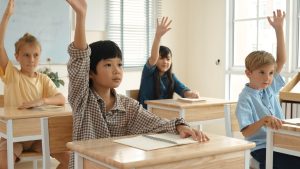 smart boy raising hand asking answering teacher classroom pedagogy